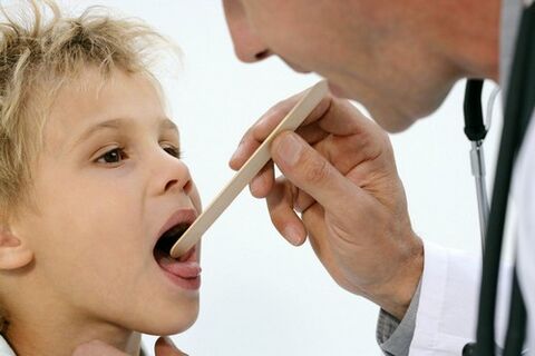 il medico esamina la gola di un bambino con psoriasi